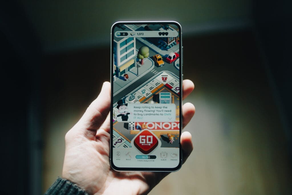 Hand holding Samsung Galaxy A56 showing a Monopoly game