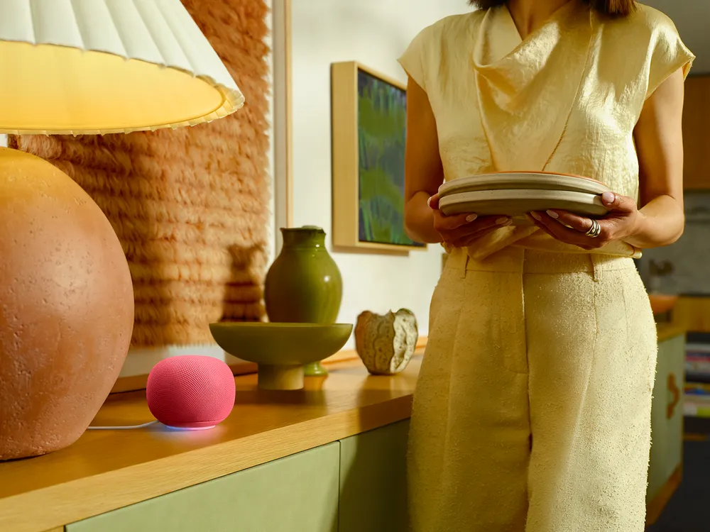 Familie i stue med Google Home-høyttaler i forgrunnen