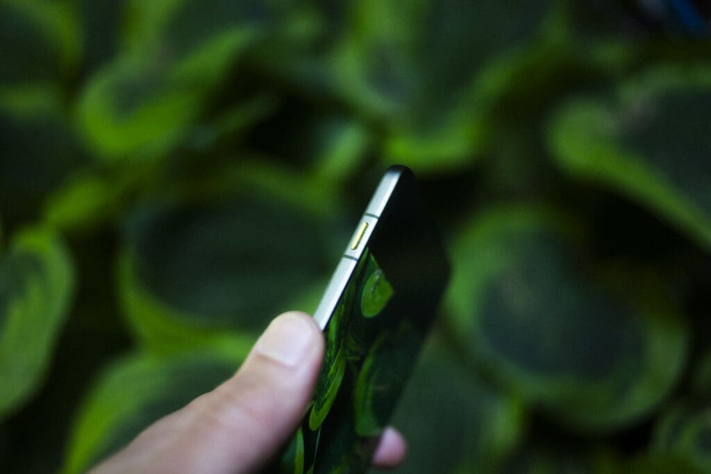 Motorola Edge 70 i sidevisning fra toppen – ultratynn profil med AI-knapp, holdt i hånden