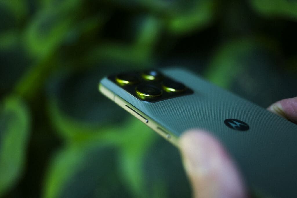 Baksiden av Motorola Edge 70 sett diagonalt ovenfra – kameramodul og rillete silikonfinish i Pantone Bronze Green