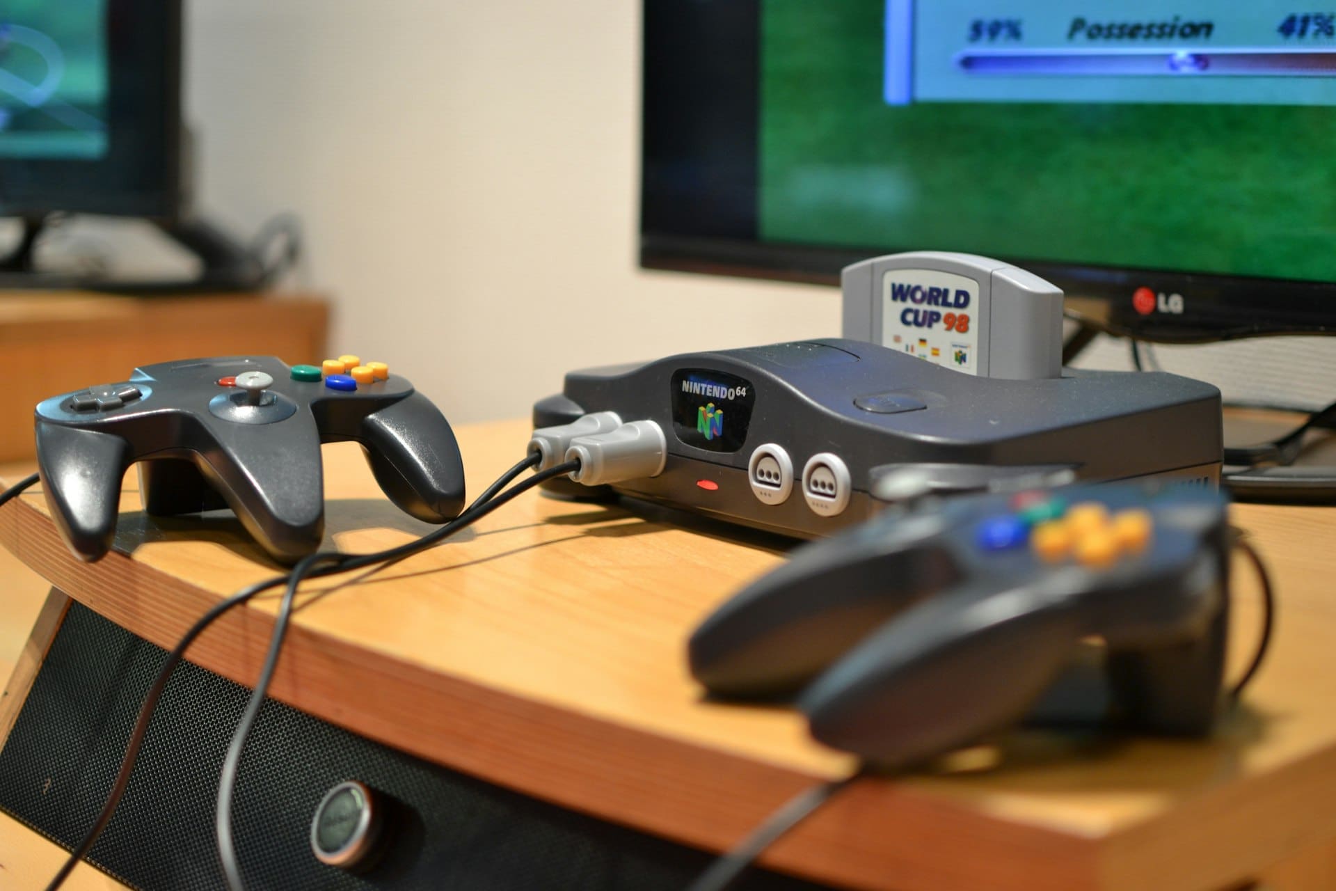 Nintendo 64-konsoll med to kontrollere koblet til en TV som viser et spill
